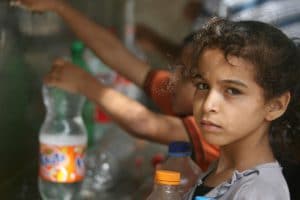 Children in Palestine collect water from one of the working public taps. Photo Flickr